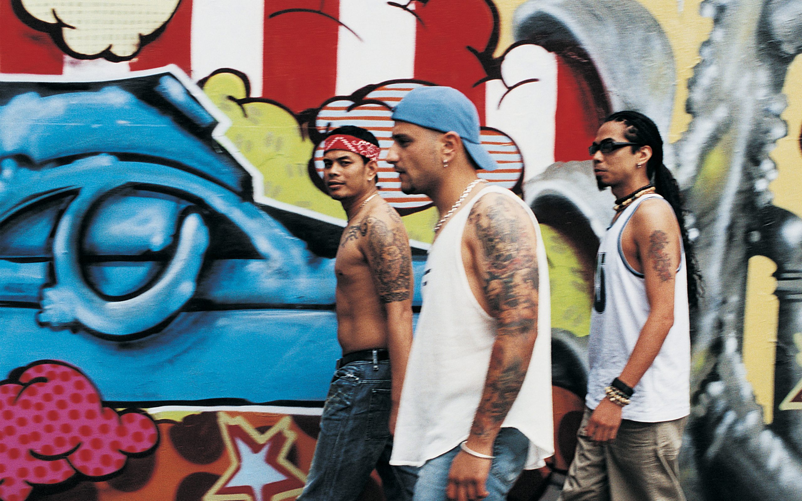 african american gentleman walking in front of graffiti