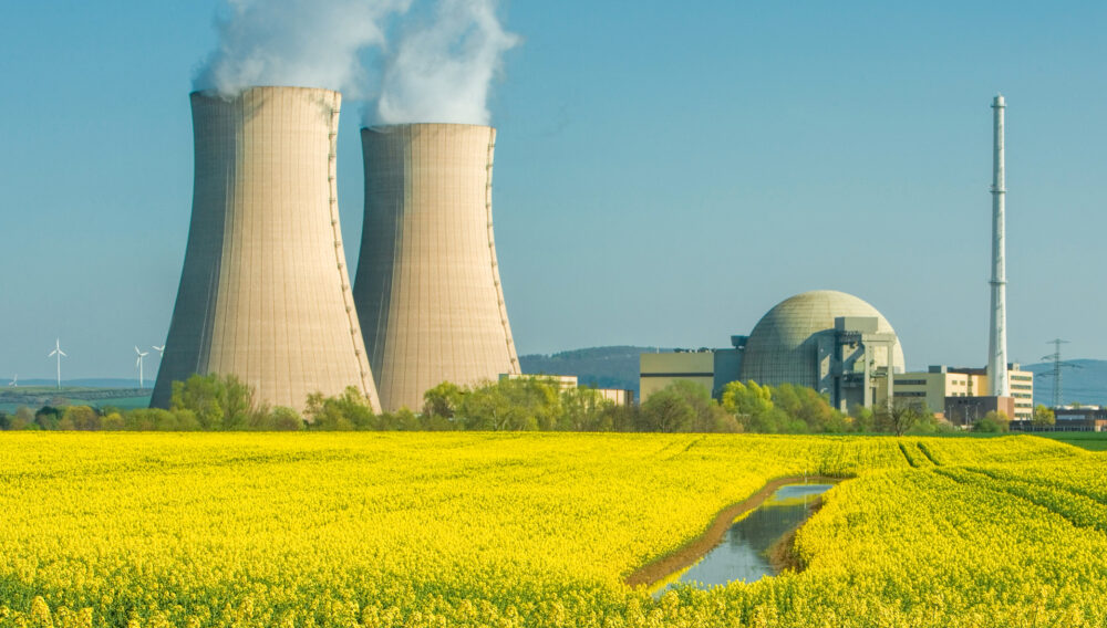 Nuclear power plant near sunny field of grain