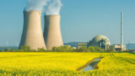 Nuclear power plant near sunny field of grain