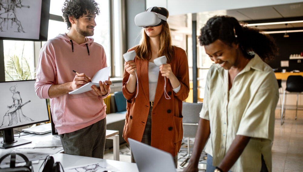 Young team of computer scientists testing a virtual reality headset and controllers