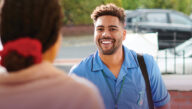 A smiling male nurse walks into work.