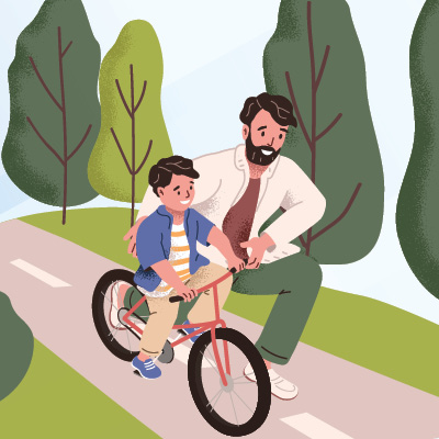 Dad helping his young child ride a bike.