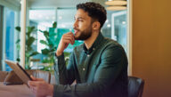 Man seated in an empty conference room with a pensive look on his face