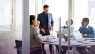 Co-workers gathered around a conference room table