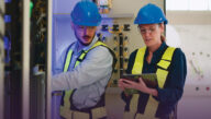 Electrical engineering technologists at work in hard hats and safety vests