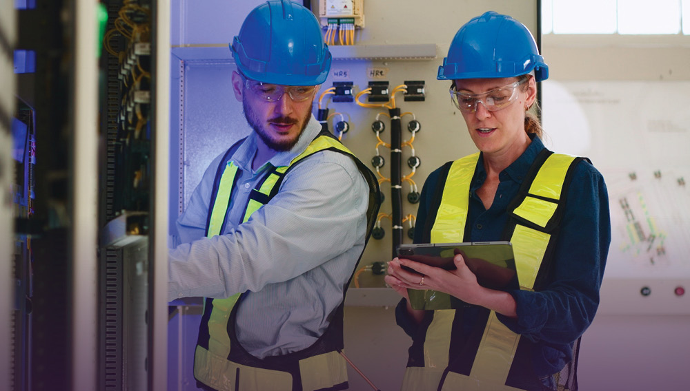 Electrical engineering technologists at work in hard hats and safety vests